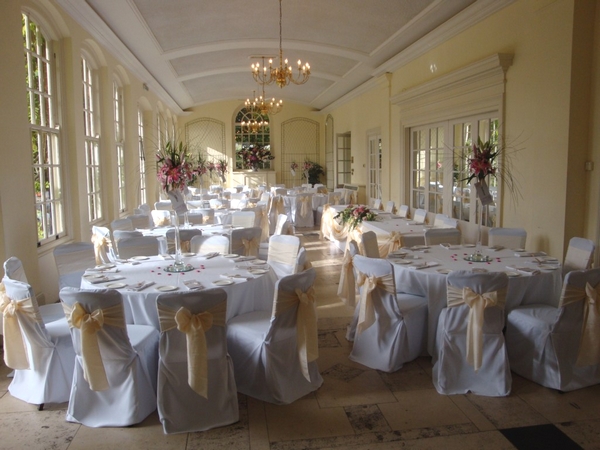Wedding reception room set up with chair covers and sashes by Ambience Venue