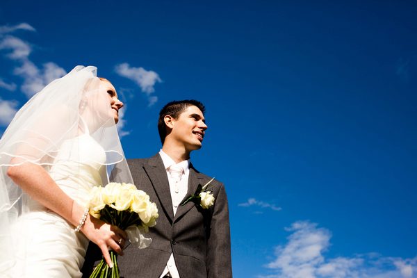 Picture of a bride and groom gazing into the bright blue sky by Sean Casey Photography