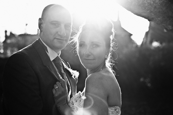 Black and white picture of bride and groom with sun shining behind them - Picture by Daniel Hough Photography