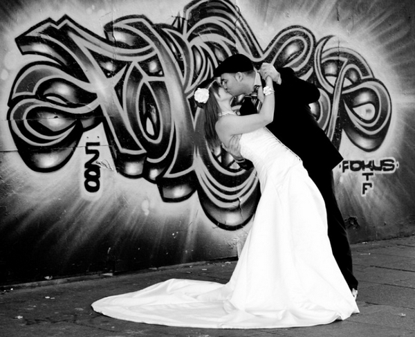 Bride and groom kissing in front of graffiti - Picture by Rosewarne Cox Photography