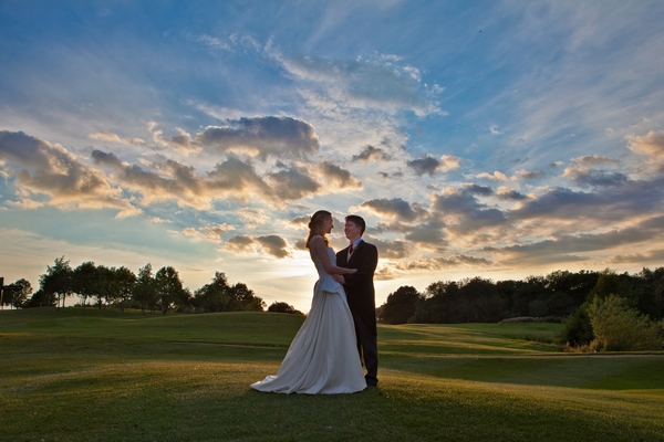 Bride and groom standing with clouds above them - Picture by Real People Photography